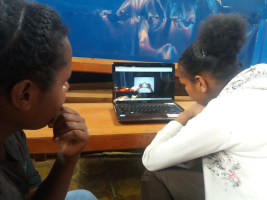 Anak-anak Wamena menggunakan laptop untuk menggunakan layanan server Perpustakaan Nirkabel