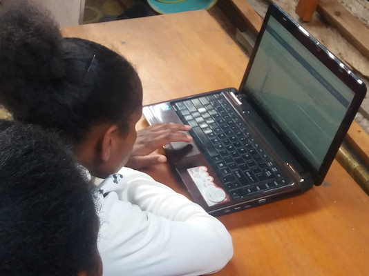 Anak-anak Wamena menggunakan laptop untuk memanfaatkan layanan server Perpustakaan Nirkabel