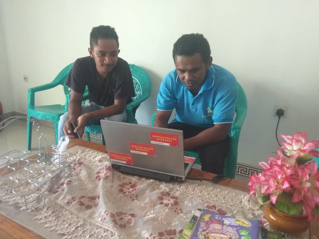Relawan literasi lokal sedang menggunakan laptop Perpustakaan Nirkabel. Foto: Rendy Valentino.